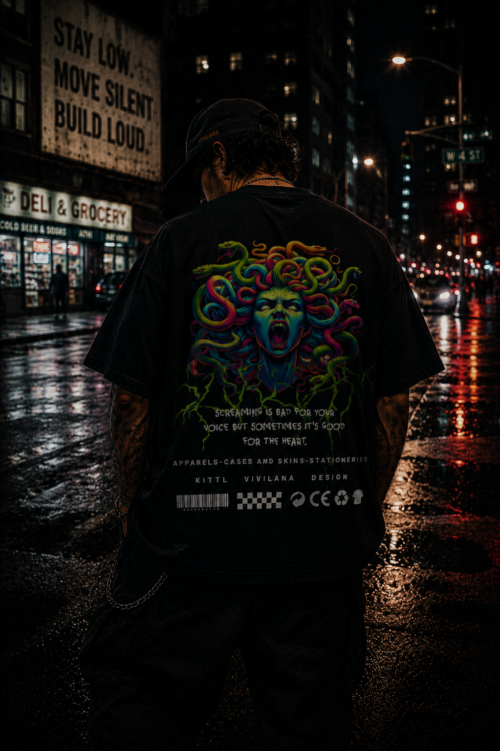 Black graphic tee with colorful Medusa design, worn on rainy city street at night